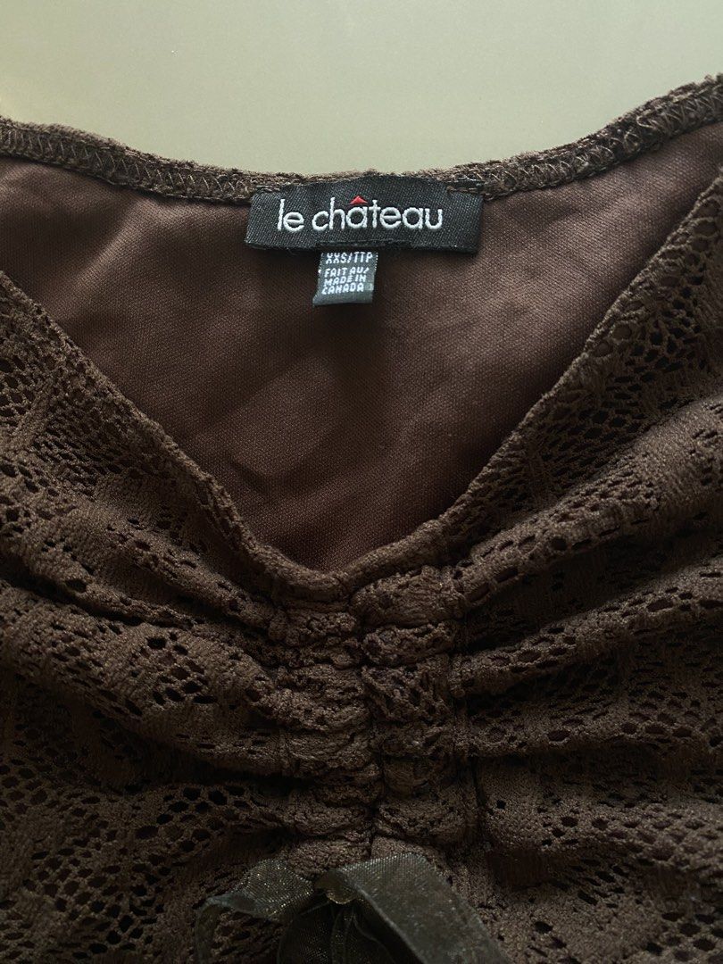 Lace Top Vintage (Category: Blouses) located in Santiago. Submitted by riceavllnz (Listing ID 1469772941, Image 3). Description: Elegant brown lace top with a romantic, feminine silhouette. • Brand: Le Château • Color: Dark chocolate brown • Design: Sheer floral lace overlay • Detail: Ruched front with ribbon tie • Neckline: Wide, off-shoulder style • Lined bodice for added coverage • Condition: Pre-loved Can fit up to semi medium Perfect for dat