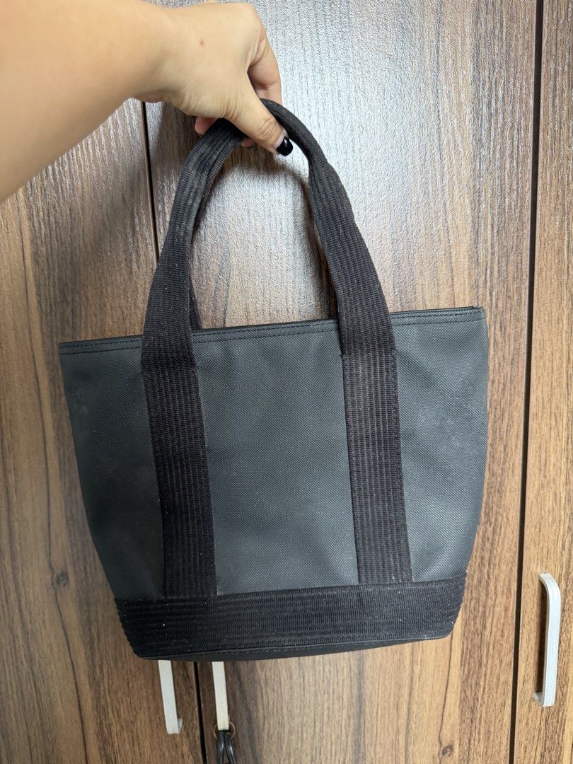 Lacoste Black Canvas Tote Bag with Embossed Logo (Category: Tote Bags) located in Quezon City. Submitted by mdjheavyequipment (Listing ID 1469788145, Image 2). Description: - Brand: Lacoste - Color: Black canvas with light cream fabric interior lining - Design: Large embossed crocodile logo on the front - Features: Double webbed fabric handles, reinforced base, and secure zip top closure - Pockets: One interior zipper pocket and open slip pockets