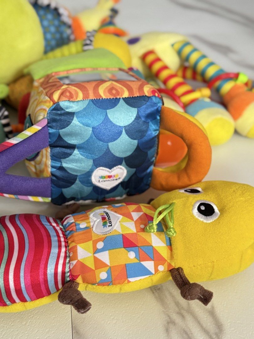 Lamaze Infant Developmental Plush Toys Bundle (Category: Infant Playtime) located in Manila. Submitted by janelica220598 (Listing ID 1469807300, Image 2). Description: Bundle of Lamaze soft baby toys. Includes multi-colored octopus, pull-along caterpillar, soft book, rattling giraffe, and hanging musical plush. High-contrast patterns, crinkle textures, squeakers, and bright colors for sensory development. Great mix of tummy time toys and clip-on 