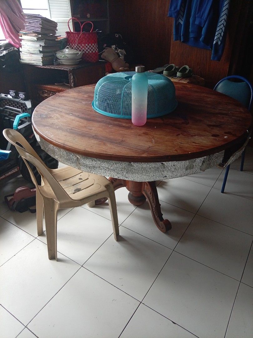 Large Round Wooden Dining Table with Pedestal Base (Category: Tables & Sets) located in Caloocan City. Submitted by maynaito (Listing ID 1469794947, Image 1). Description: - Solid wood construction with a sturdy, heavy build - Elegant carved pedestal base and deep brown tabletop finish - Unique silver protective edging wrapped around the rim - Good size for family meals and gatherings - Shows normal signs of previous use on the surface - Pick up 