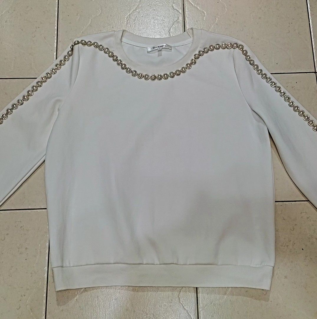 LesBabies Elegant Gemstone Embellished Top (Category: Coats, Jackets and Outerwear) located in Quezon City. Submitted by chph3rd (Listing ID 1469764088, Image 3). Description: - Color: White - Style: Long-sleeve sweatshirt with rhinestone and pearl trim on neckline and outer sleeves - Material: Soft cotton blend - Details: Ribbed crewneck, cuffs, and hem - Condition: Excellent, clean with no stains or damage .