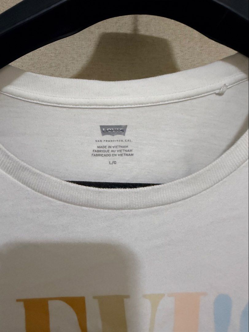 Levi's White Graphic T-shirt Size L (Category: Shirts) located in Cavite. Submitted by mgd.blessed (Listing ID 1469904748, Image 2). Description: - Brand: Levi's - Color: White with multicolored pastel logo - Size: Large - Material: 100% Comfortable cotton - Origin: Made in Vietnam - Style: Short sleeves, crew neck - Condition: Great for casual everyday wear, easy to match with jeans or shorts -fits M-L.