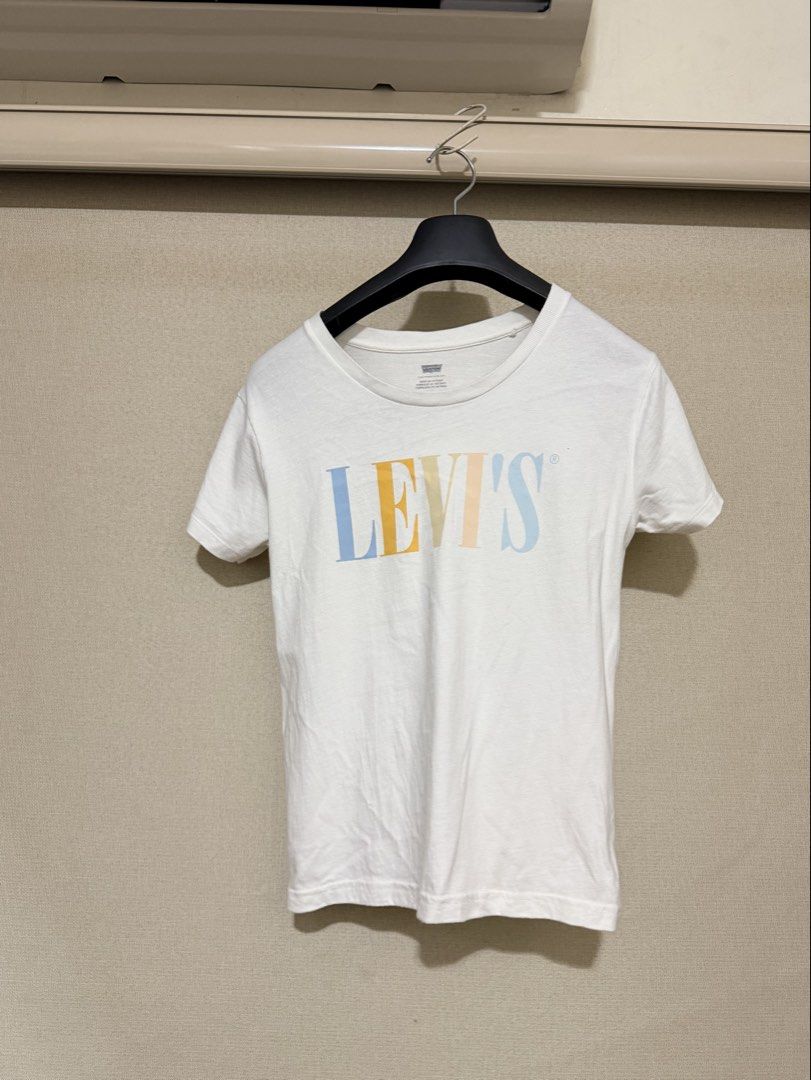 Levi's White Graphic T-shirt Size L (Category: Shirts) located in Cavite. Submitted by mgd.blessed (Listing ID 1469904748, Image 1). Description: - Brand: Levi's - Color: White with multicolored pastel logo - Size: Large - Material: 100% Comfortable cotton - Origin: Made in Vietnam - Style: Short sleeves, crew neck - Condition: Great for casual everyday wear, easy to match with jeans or shorts -fits M-L.