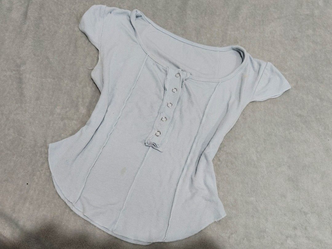 Light blue ribbed button-front short sleeve top (Category: Blouses) located in San Juan City. Submitted by rhennx (Listing ID 1469898962, Image 1). Description: - Color: Baby blue - Need wash (has light stains) - Fabric: Soft, stretchy ribbed material - Design: Scoop neck with functional front snap buttons - Fit: Fitted silhouette with vertical exposed seam details and a curved hem - Perfect for effortless everyday casual wear.