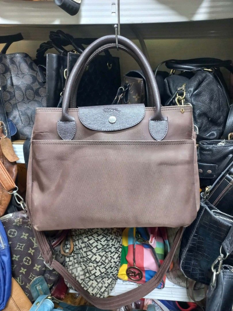 Longchamp Le Pliage Brown Tote Bag (Category: Luxury Bags & Wallets) located in Manila. Submitted by dei03_diz (Listing ID 1469872145, Image 1). Description: - Authentic Longchamp brown nylon tote bag - Features leather top handles, flap, and a convenient long shoulder strap - Main zipper closure with an additional front pocket - Interior includes signature horse print lining, zipped pocket, and Paris manufacture tag - Condition: Shows visible si