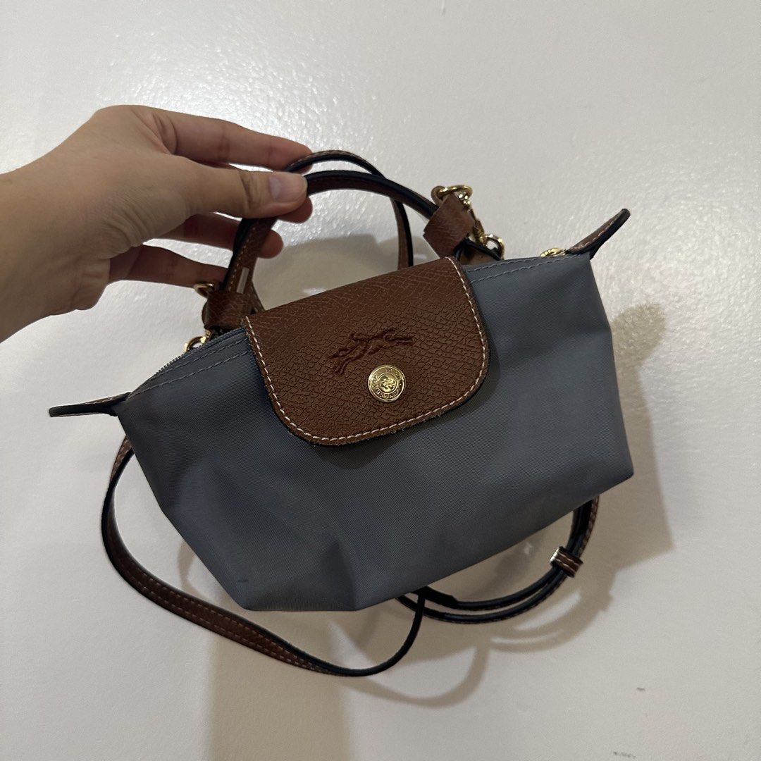 Longchamp Le Pliage Cuir Extra Small Top Handle Bag (Category: Luxury Bags & Wallets) located in Makati City. Submitted by cosmicfire.4ba272 (Listing ID 1469840179, Image 1). Description: - Color & Material: Grey nylon body with stylish brown leather flap and handle trim - Hardware: Elegant gold-tone snap button closure and details - Closure: Secure zippered top to keep your items safe - Versatility: Includes a detachable crossbody strap for hand