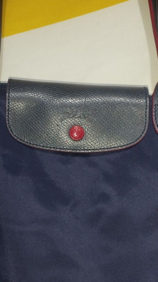 Longchamp Le Pliage Nylon Tote Bag Navy Blue (Category: Luxury Bags & Wallets) located in Manila. Submitted by beckster_online_luxuryshop (Listing ID 1469901161, Image 2). Description: - Brand: Longchamp - Color: Navy blue with contrasting red edging and red embroidered jockey logo - Material: Lightweight, durable nylon - Closure: Flap closure with snap button and embossed horse logo - Condition: Clean with minimal signs of wear - Features: Folds