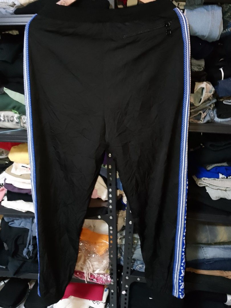 Louis Vuitton Monogram Side Stripe Jogger Pants (Category: Joggers) located in Manila. Submitted by mjthrifted_second (Listing ID 1469806093, Image 2). Description: - Brand: Louis Vuitton - Color: Black with blue & white monogram side stripes - Size: XL - Made in Italy - Material: Nylon and cotton outer with polyester lining - Features: Elastic drawstring waistband and secure back zip pocket - Condition: Comfort meets high-end streetwear style.