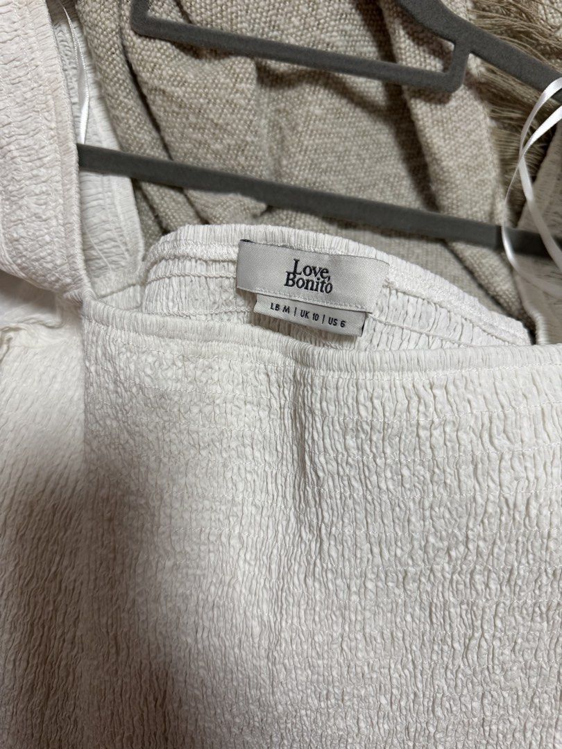 Love Bonito White Smocked Square Neck Top (Category: Blouses) located in Calamba. Submitted by cheriiv (Listing ID 1469912058, Image 3). Description: Washed, never worn - Brand: Love Bonito - Color: White - Size: M (UK 10 / US 6) - Design: Square neckline, short puff sleeves, and trendy all-over smocked texture - Material: Super stretchy and comfortable - Measurements: Length 44 cm, Bust 79 cm, Waist 72 cm - Perfect for pairing with high-waisted 