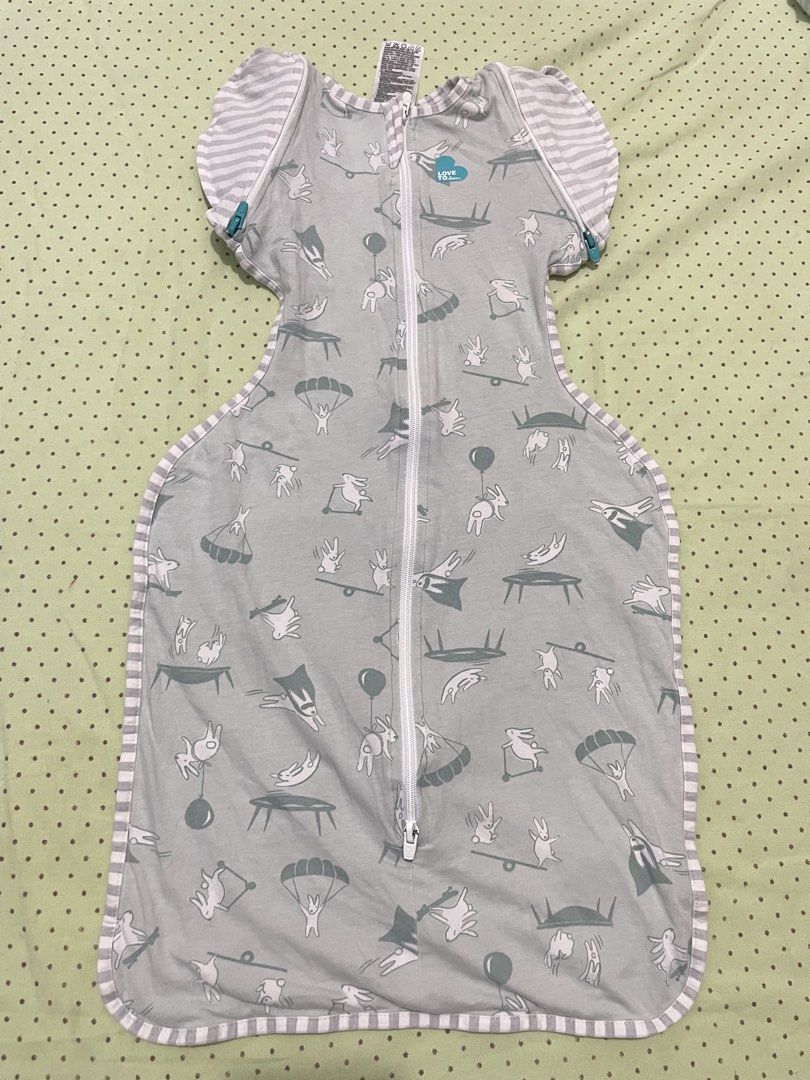Love To Dream Swaddle Up Transition Bag Lite Medium (Category: Breastfeeding & Bottle Feeding) located in San Jose del Monte. Submitted by momma_buys (Listing ID 1469830159, Image 1). Description: - Brand: Love To Dream Swaddle Up Transition Bag Lite - Size: Medium (00), fits babies 6-8.5 kgs / 13-19 lbs (approx. 3-6 months) - Material: 97% cotton, 3% elastane (ideal for warm weather) - Design: Grey with playful bunny pattern and striped wing sle