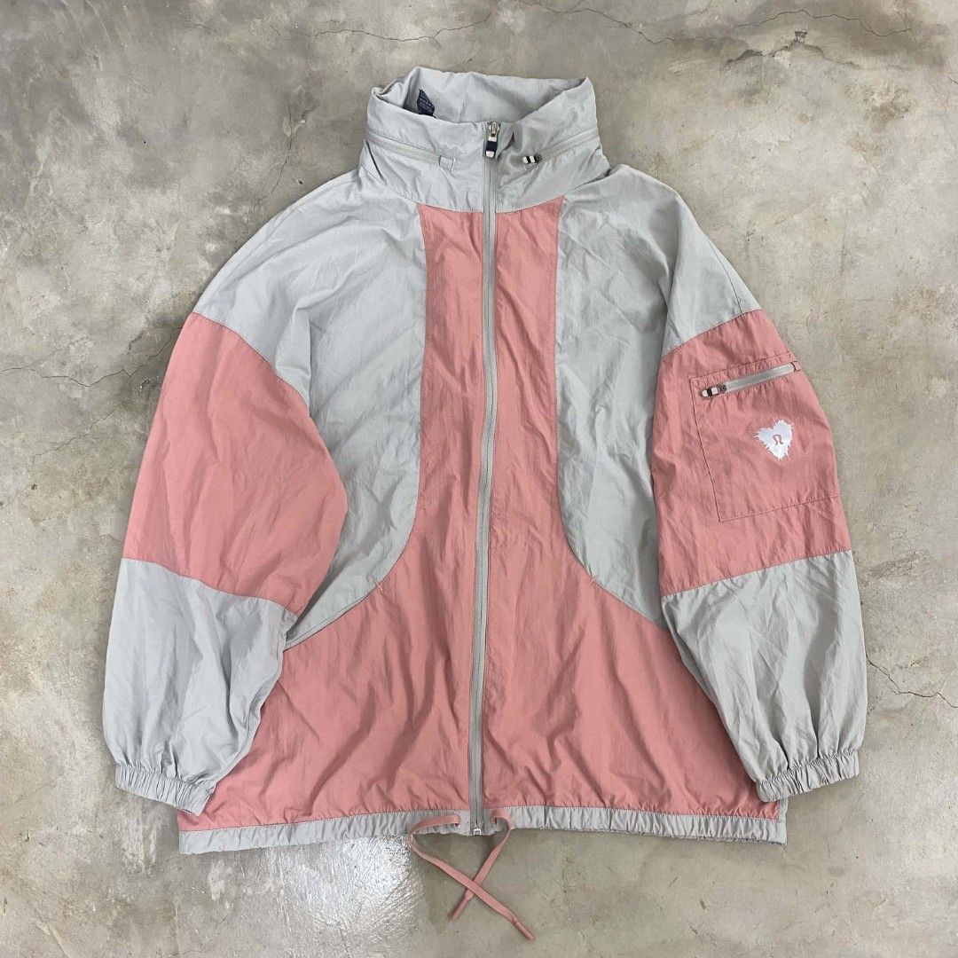 Lululemon Colourblocked Windbreaker Jacket Pink Grey (Category: Coats, Jackets and Outerwear) located in Manila. Submitted by rodeltzy (Listing ID 1469826795, Image 2). Description: - Brand: Lululemon - Style: Zip-up windbreaker in a light grey and pink colourblock design - Features: Packable hood and adjustable drawstrings at the hem - Pockets: Sleeve pocket with a small zipper and graphic heart logo print - Details: Classic omega logo stamped n
