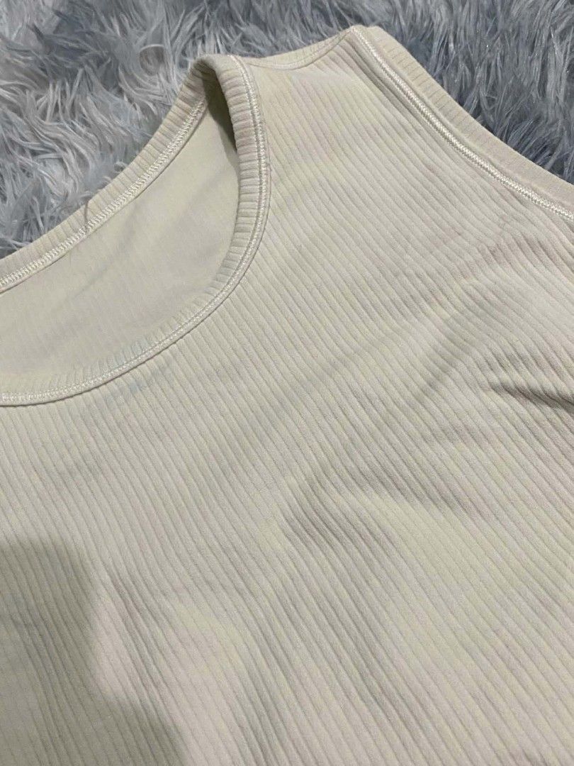 Lululemon Ribbed Tank Top Cream (Category: Sleeveless) located in Manila. Submitted by gemfinds650 (Listing ID 1469901842, Image 3). Description: - Brand: Lululemon - Color: Classic Cream - Style: Round neckline, sleeveless ribbed tank top - Details: Signature silver omega logo at the upper back collar - Fabric: Soft, high-stretch, comfortable material - Condition: Excellent / Great basic piece - Perfect for: Gym workouts, yoga, running errands, 