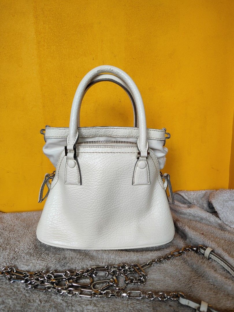 Maison Margiela 5AC Micro White Leather Bag (Category: Luxury Bags & Wallets) located in Cebu City. Submitted by cherreymie70208 (Listing ID 1469786172, Image 2). Description: - Maison Margiela 5AC Micro Bag -Repainted color on leather lips part inside - Color: Textured White Leather - Features iconic numeric logo patch and metal feet on bottom - Dual top handles and detachable chain strap included - Secure zip closure with interior tag (Style co