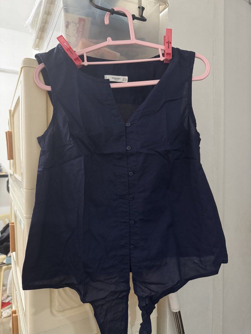 Mango Dark Blue Sleeveless Button-Down Blouse (Category: Sleeveless) located in Manila. Submitted by nicefinds (Listing ID 1469828772, Image 1). Description: - Brand: Mango - Color: Dark blue - Style: Sleeveless V-neck blouse with front buttons and tied hem detail - Fit: Regular fit, lightweight and slightly sheer fabric - Condition: Clean and ready to wear - Ideal for: Warm weather or layering.