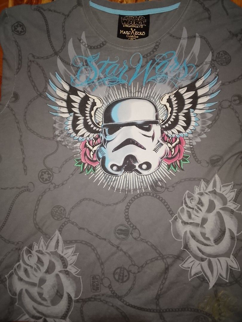 Marc Ecko Star Wars Stormtrooper T-Shirt 2XL (Category: Tshirts & Polo Shirts ) located in Gapan. Submitted by alfiesimon43550 (Listing ID 1469874652, Image 1). Description: - StarWars - Brand: Marc Ecko Cut & Sew (Official 2008 Lucasfilm merch) - Design: Large Stormtrooper graphic with wings, roses, and all-over chain print - Color: Gray with light blue neckline trim - Size: 2XL - Material: 100% Cotton (Made in Mexico) - Condition: Excellent pre