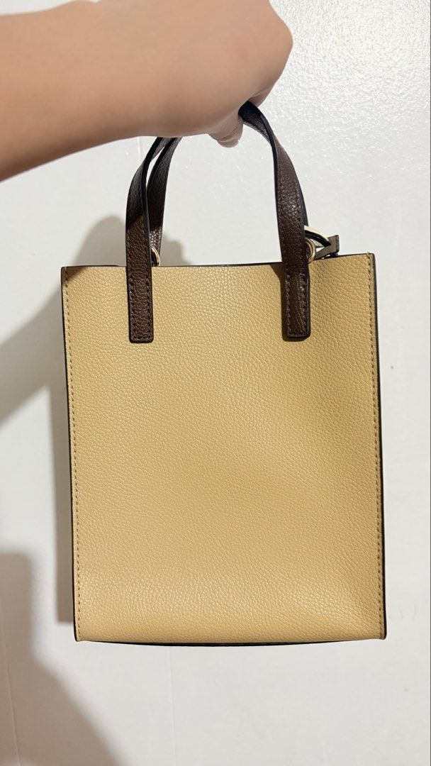 Marc Jacobs Leather Tote Bag (Category: Tote Bags) located in Baguio. Submitted by meiji50 (Listing ID 1469930120, Image 2). Description: Marc Jacobs tote bag in a multi-tone beige, brown, and cream colorway. Textured pebbled leather material with structured upright handles. Front slip pocket accented with a gold-tone padlock and key charm. Clean dark interior lining. Includes original brand tag tucked in the front pocket..