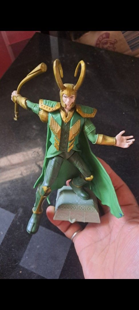 Marvel Loki figurine with staff and green cape (Category: Figurines & Statues) located in Davao. Submitted by bravemoon_556cd5 (Listing ID 1469876153, Image 2). Description: - Character: Loki (Marvel Universe) - Design: Signature green and gold costume, horned helmet, and flowing green cape - Accessories: Holding a curved staff - Base: Includes a detailed decorative stand - Condition: Good size for shelf or desk display, ready for a new home.