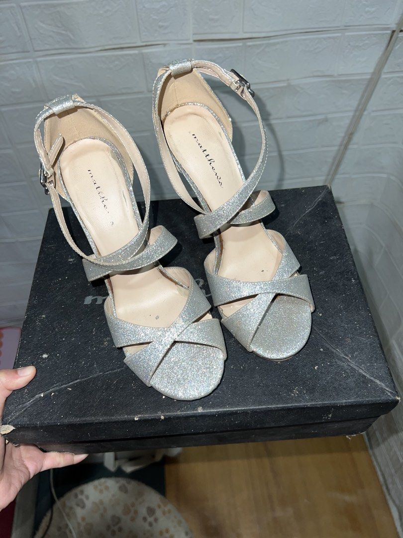 Matthews Silver Glitter Stilettos Heels (Category: Heels) located in Santa Rosa. Submitted by truecat.9d0628 (Listing ID 1469895262, Image 1). Description: - Brand: Matthews - Color/Finish: Silver glitter - Style: Strappy high heels with open toe and ankle buckle closure - Inclusions: Original black box and dust cover - Condition: Signs of wear visible on the inner sole and edges.