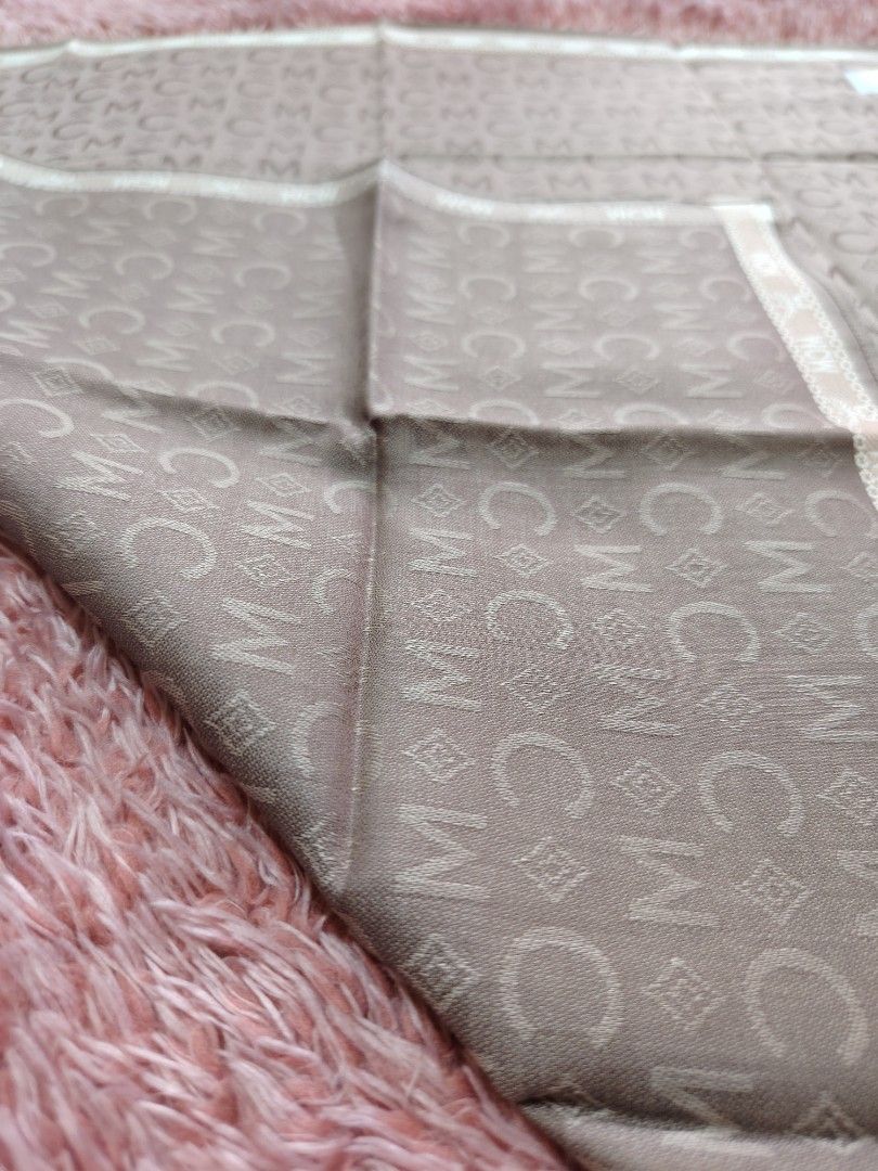 MCM Hanky NEW (Category: Scarves) located in Valenzuela. Submitted by anna.banana10 (Listing ID 1469788305, Image 3). Description: - Brand: MCM - Material: Lightweight silk - Design: All-over monogram pattern with MCM and C motifs, finished with a cream and brown patterned border - Details: Features a gold-tone fabric brand label and original tag attached - Shape: Square - Condition: Brand new with original tag; has minor folded crease lines from