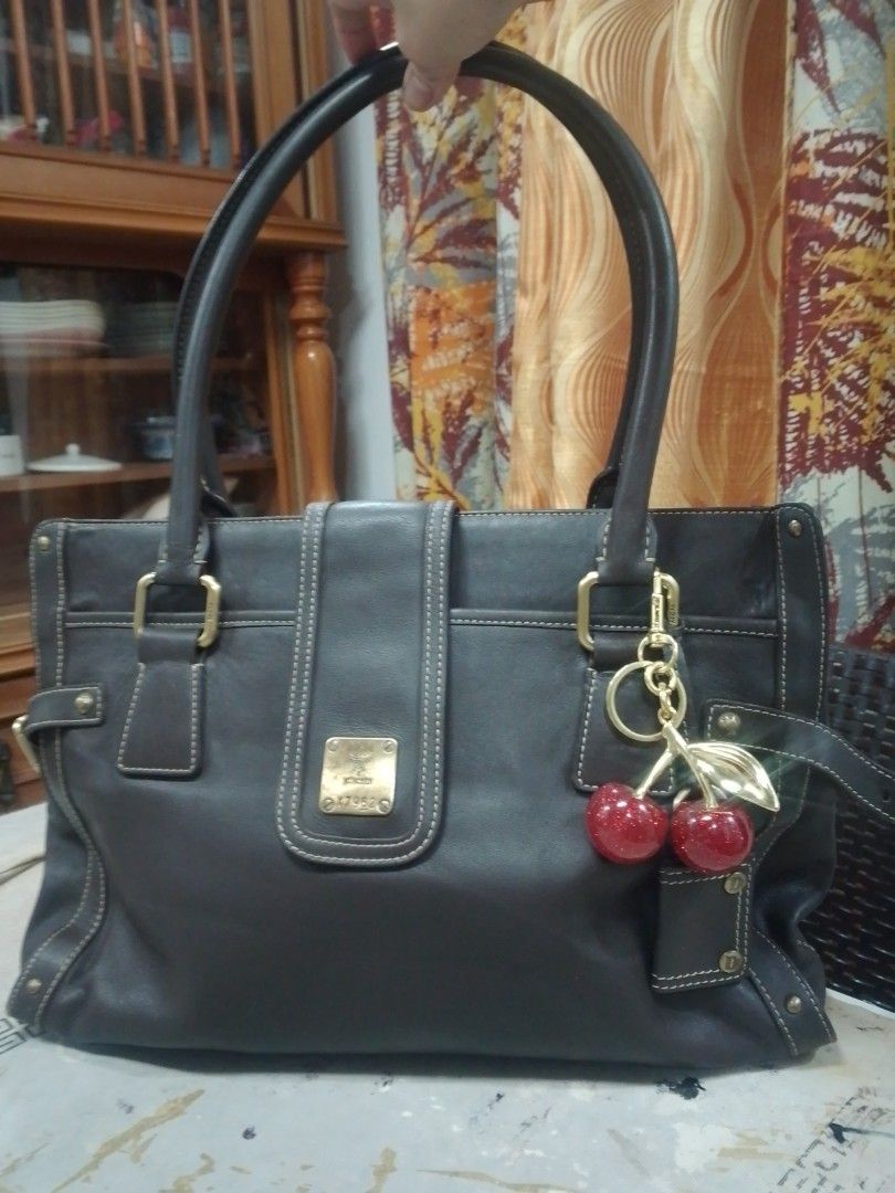 MCM Munich Dark Grey Leather Tote Bag (Category: Luxury Bags & Wallets) located in Manila. Submitted by annemil_1984 (Listing ID 1469825384, Image 1). Description: Dark grey leather tote bag from MCM München. Sturdy structured shape, double shoulder straps, silver-tone hardware accents, front plaque stamped with serial number X7962. Fabric lined interior with zip pocket and Sungjoo D&D tag. Cream contrast stitching throughout. Practical everyday 