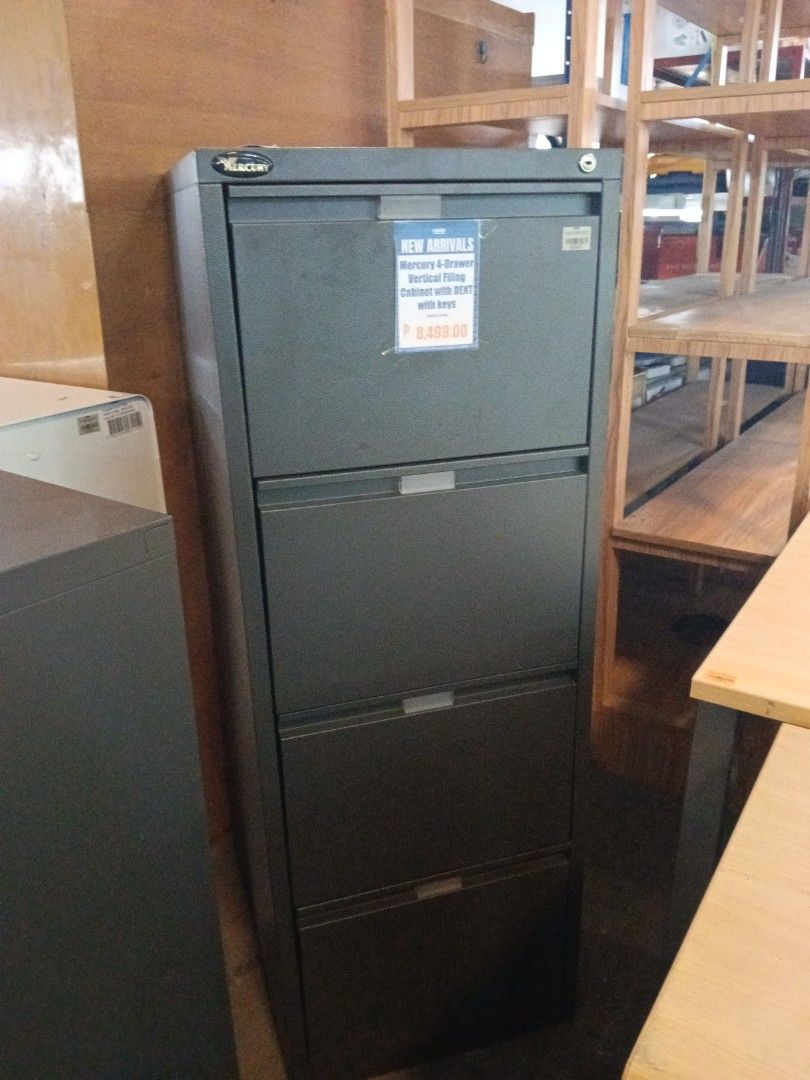 Mercury 4-Drawer Vertical Filing Cabinet with Keys (Category: Office Furniture & Fixtures) located in Manila. Submitted by jesicahmrsantarosa (Listing ID 1469796350, Image 2). Description: Mercury 4-drawer vertical filing cabinet in dark grey. Includes keys. Has a dent near the top drawer label area. Sturdy metal build, lots of storage space for office files, documents, or paperwork. Standard office size..