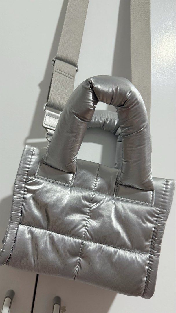 Metallic Silver Puffer Crossbody Bag with Strap (Category: Cross-body Bags) located in Manila. Submitted by trixiasanj76620 (Listing ID 1469792751, Image 1). Description: - Trendy silver metallic puffer tote bag with all-over quilted design - Lightweight and catches the light nicely - Dual puffed top handles and a thick adjustable light grey crossbody strap - Main compartment with a secure center snap button tab - Built-in inside slip pockets for