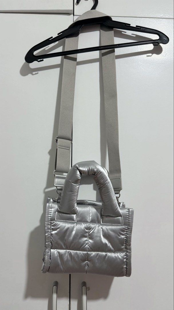 Metallic Silver Puffer Crossbody Bag with Strap (Category: Cross-body Bags) located in Manila. Submitted by trixiasanj76620 (Listing ID 1469792751, Image 3). Description: - Trendy silver metallic puffer tote bag with all-over quilted design - Lightweight and catches the light nicely - Dual puffed top handles and a thick adjustable light grey crossbody strap - Main compartment with a secure center snap button tab - Built-in inside slip pockets for