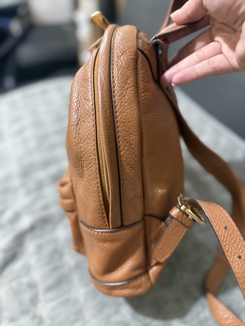 Michael Kors Brown Leather Backpack (Category: Backpacks) located in Quezon City. Submitted by vianca13 (Listing ID 1469817333, Image 2). Description: - Brand: Michael Kors - Material: Brown pebble leather with gold hardware - Straps: Top handle and adjustable shoulder straps - Pockets: Front zipped pocket, main compartment, interior zip pocket, and slip slots - Lining: Signature logo interior lining - Small to semi med size .