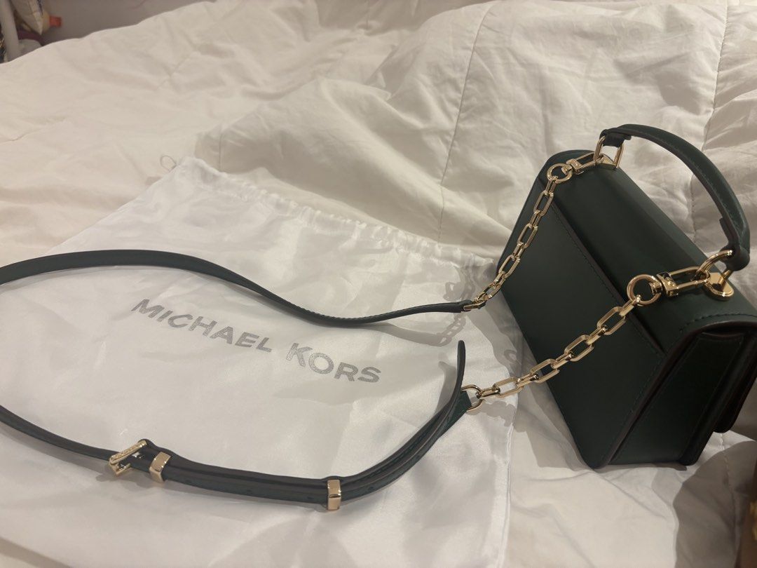 Michael Kors Green Leather Crossbody Bag (Category: Cross-body Bags) located in Quezon City. Submitted by kindakristelle2481 (Listing ID 1469878657, Image 3). Description: Dark green Michael Kors crossbody handbag with gold hardware. Circular MK logo on the front flap and square turn-lock closure. Adjustable strap and top handle included. Branded fabric lining inside with a Michael Kors logo tag. Includes white dust bag..