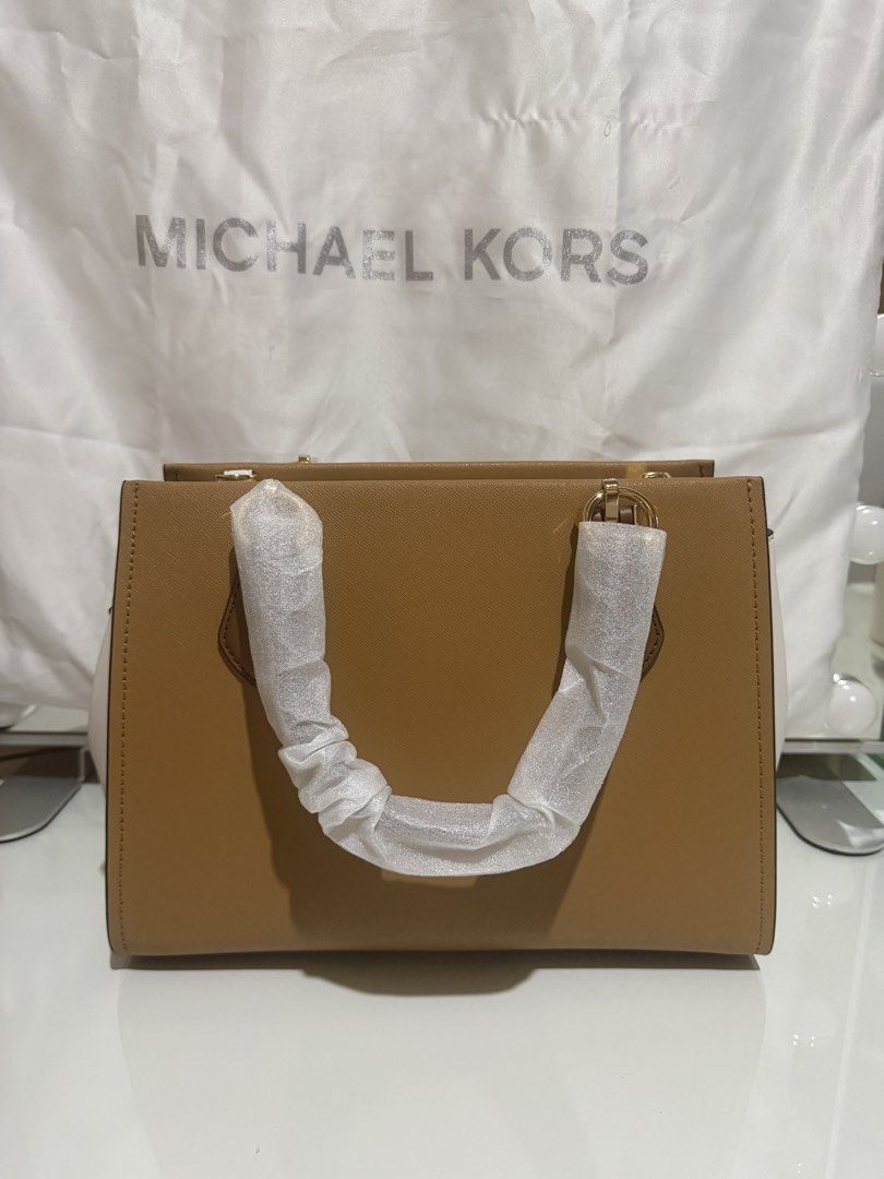 Michael Kors Two-Tone Satchel Bag (Category: Luxury Bags & Wallets) located in Quezon City. Submitted by prelovedbyjrl (Listing ID 1469875417, Image 2). Description: Brand: Michael Kors Color: Tan and White with Gold-tone hardware Condition: Brand new (handles wrapped in protective foam, strap stuffed inside) Design: Structured silhouette with top zip closure and side gussets Versatility: Includes double top handles and an adjustable shoulder str