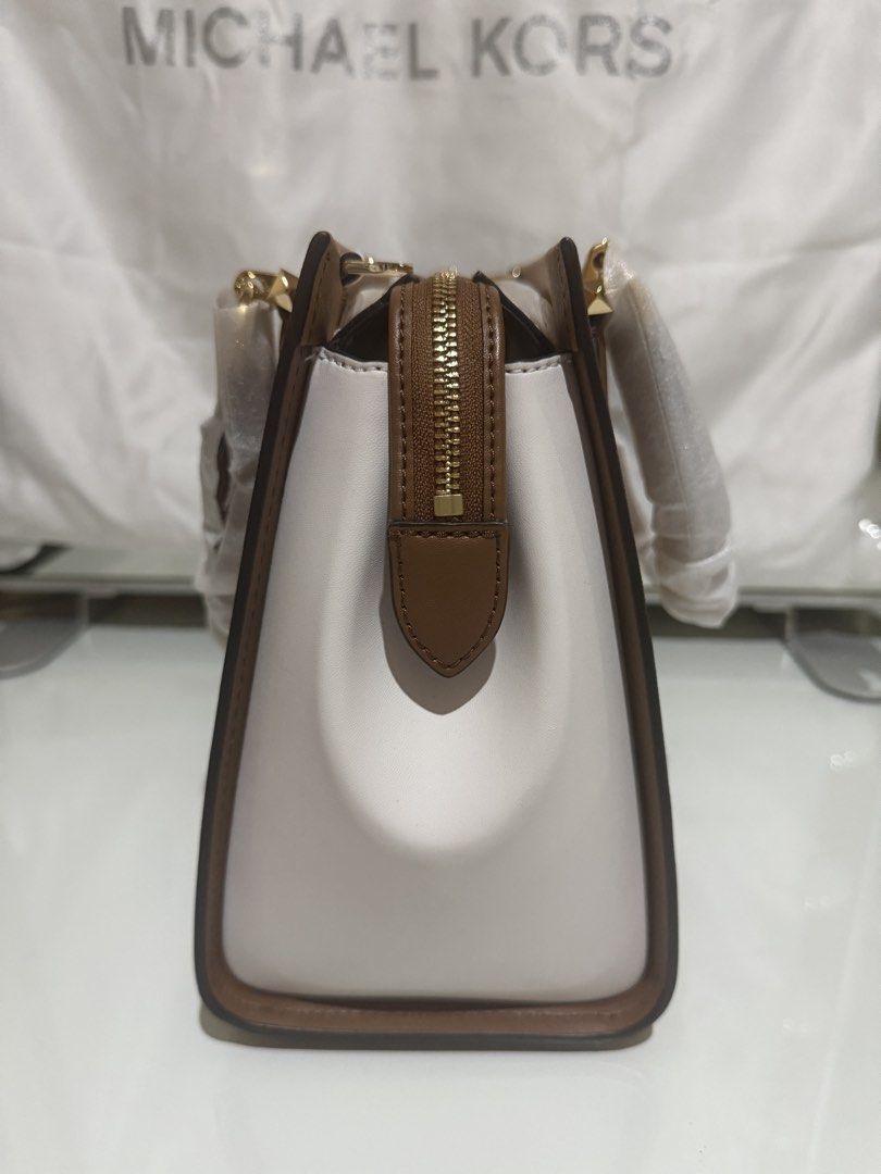 Michael Kors Two-Tone Satchel Bag (Category: Luxury Bags & Wallets) located in Quezon City. Submitted by prelovedbyjrl (Listing ID 1469875417, Image 3). Description: Brand: Michael Kors Color: Tan and White with Gold-tone hardware Condition: Brand new (handles wrapped in protective foam, strap stuffed inside) Design: Structured silhouette with top zip closure and side gussets Versatility: Includes double top handles and an adjustable shoulder str