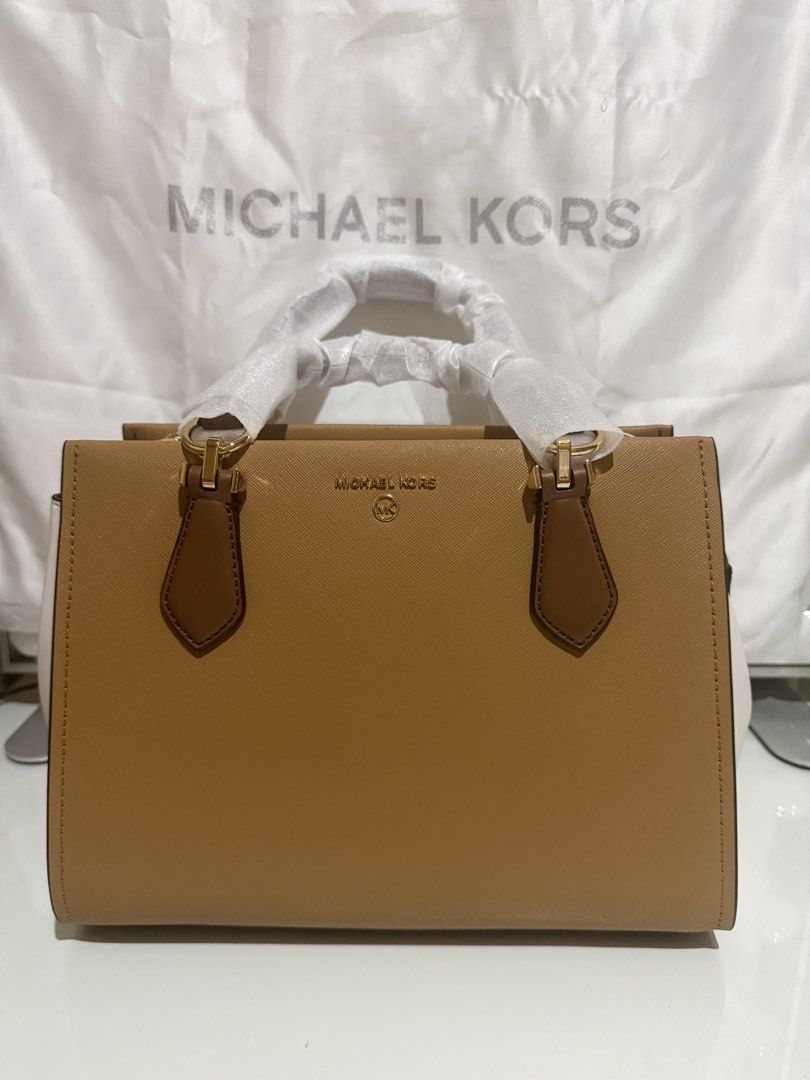 Michael Kors Two-Tone Satchel Bag (Category: Luxury Bags & Wallets) located in Quezon City. Submitted by prelovedbyjrl (Listing ID 1469875417, Image 1). Description: Brand: Michael Kors Color: Tan and White with Gold-tone hardware Condition: Brand new (handles wrapped in protective foam, strap stuffed inside) Design: Structured silhouette with top zip closure and side gussets Versatility: Includes double top handles and an adjustable shoulder str