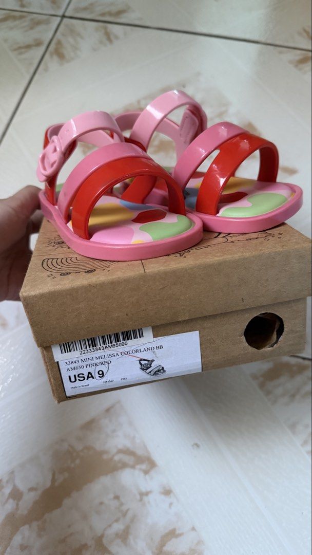 Mini Melissa Sandals (Category: Flats & Sandals) located in Tagaytay City. Submitted by alexaerina (Listing ID 1469776726, Image 2). Description: - Brand: Mini Melissa Colorland - Color: Pink and red colorway - Size: USA 9, EUR 25/26, BRA 23/24 - Material: Vegan, 100% waterproof jelly - Features: Adjustable buckle strap, fun abstract printed insole - Inclusion: Comes with original shoe box - 100% auth bought from store, EUC.