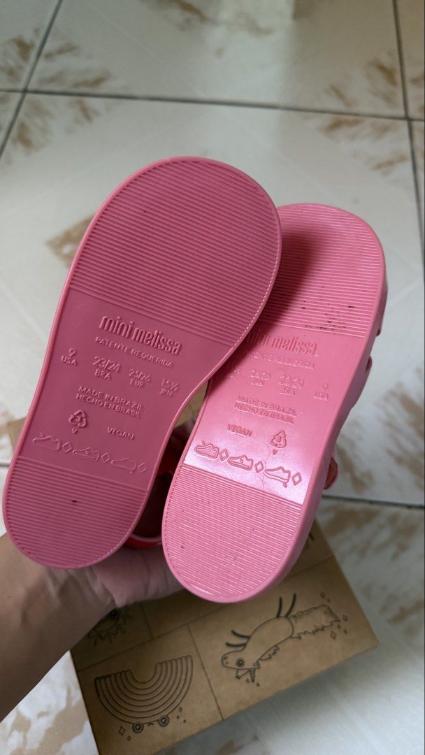 Mini Melissa Sandals (Category: Flats & Sandals) located in Tagaytay City. Submitted by alexaerina (Listing ID 1469776726, Image 3). Description: - Brand: Mini Melissa Colorland - Color: Pink and red colorway - Size: USA 9, EUR 25/26, BRA 23/24 - Material: Vegan, 100% waterproof jelly - Features: Adjustable buckle strap, fun abstract printed insole - Inclusion: Comes with original shoe box - 100% auth bought from store, EUC.