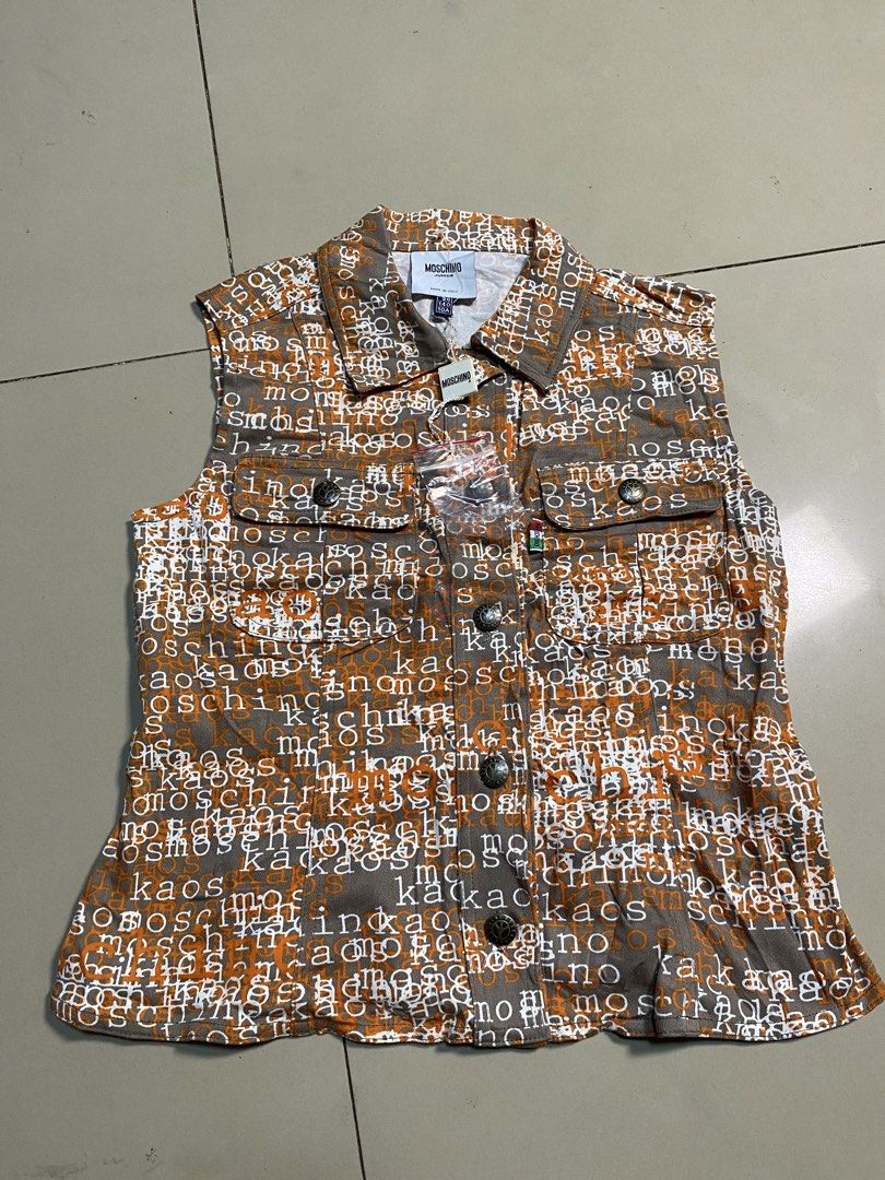 Moschino Junior All-Over Print Denim Vest (Category: Sleeveless) located in Binalbagan. Submitted by southsidethrift22 (Listing ID 1469890573, Image 1). Description: - Brand: Moschino Junior - Item: Sleeveless denim vest - Size: 10A / 140 - Design: Brown and orange fabric with white all-over typography print - Features: Button-up front closure, dual chest pockets with button flaps, branded metal hardware - Origin: Made in Italy - Condition: Brand