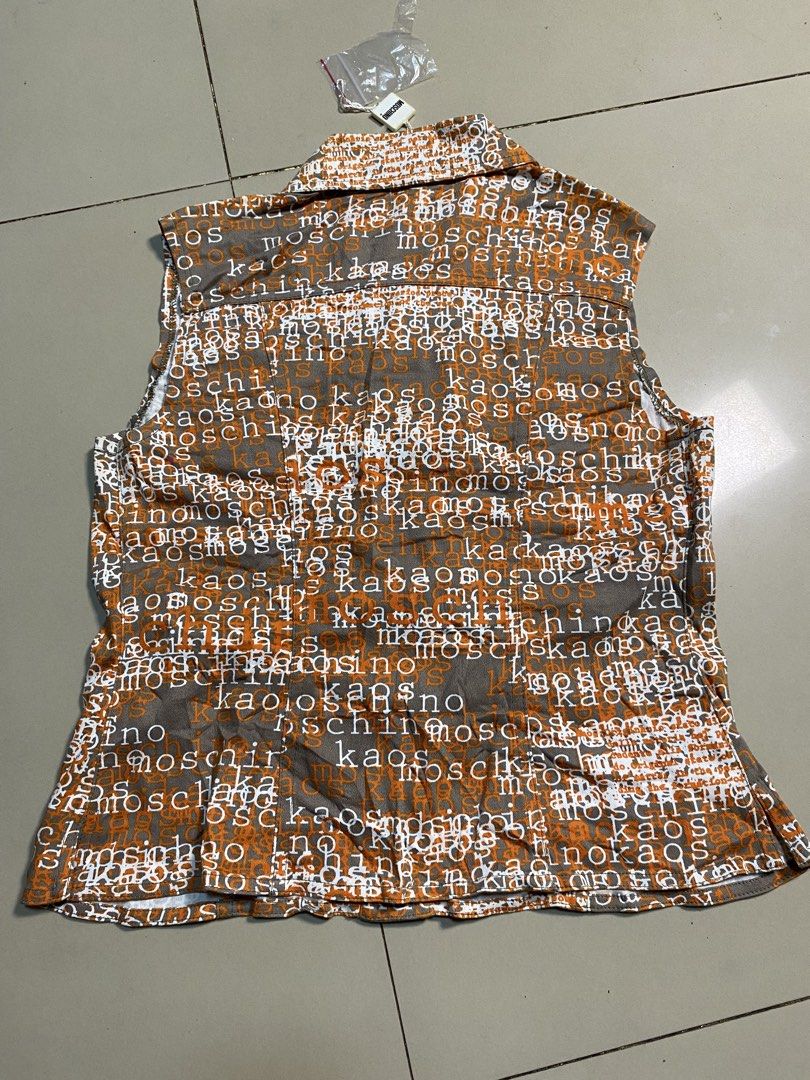 Moschino Junior All-Over Print Denim Vest (Category: Sleeveless) located in Binalbagan. Submitted by southsidethrift22 (Listing ID 1469890573, Image 2). Description: - Brand: Moschino Junior - Item: Sleeveless denim vest - Size: 10A / 140 - Design: Brown and orange fabric with white all-over typography print - Features: Button-up front closure, dual chest pockets with button flaps, branded metal hardware - Origin: Made in Italy - Condition: Brand