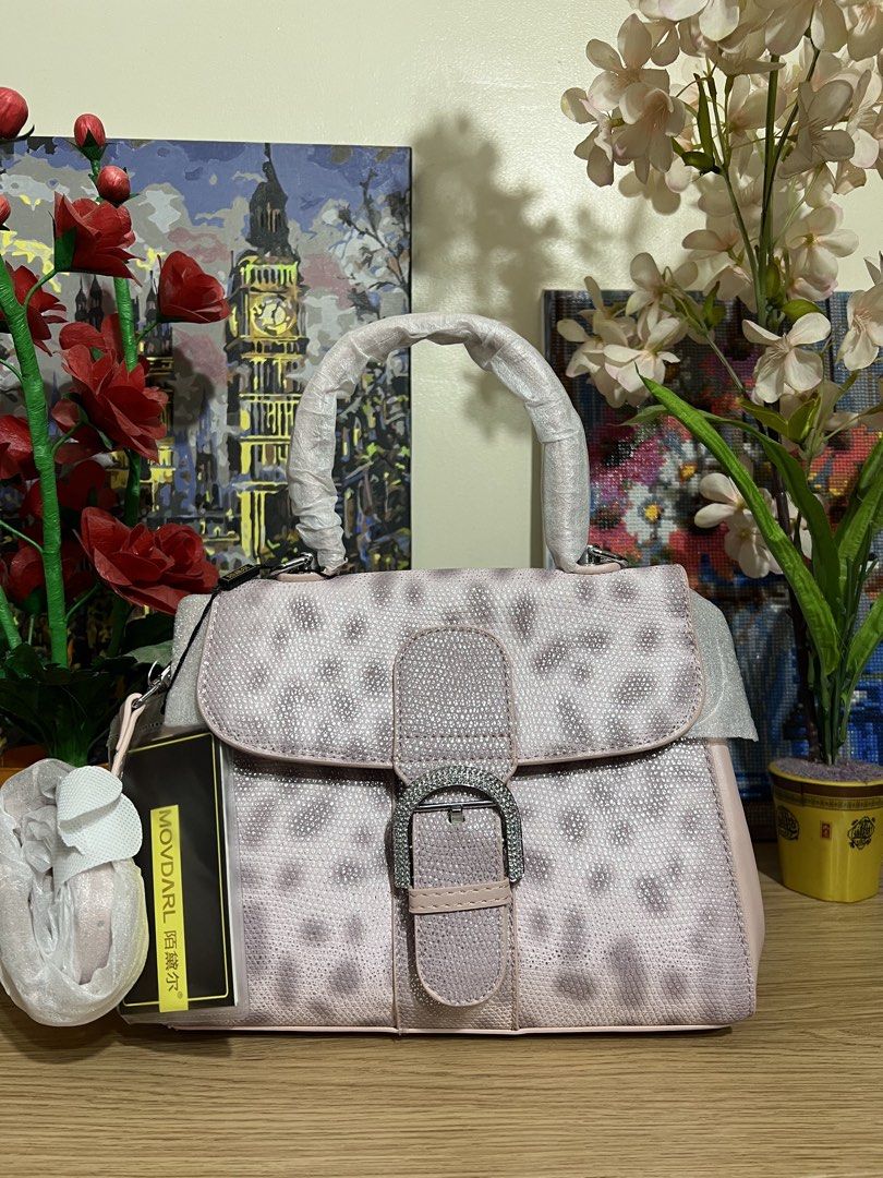 Movdarl Top Handle Bag with Rhinestone Buckle (Category: Luxury Bags & Wallets) located in Mandaue City. Submitted by celinecious (Listing ID 1469867548, Image 3). Description: - Brand: Movdarl (Brand new with tag attached) - Design: Textured finish with chic animal print patterns - Closure: Front flap with eye-catching rhinestone accented buckle - Condition: Handles still in original protective packaging - Strap: Includes a detachable shoulder s