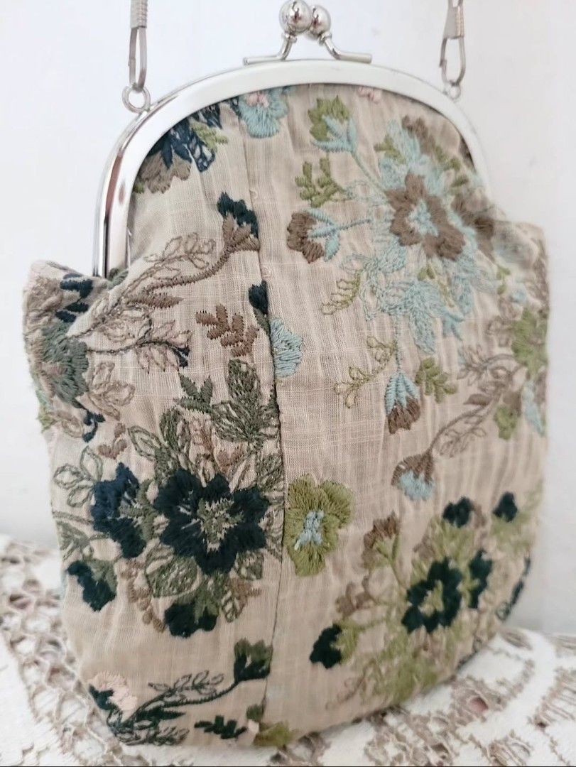 Muted Embroidered Kisslock Bag (Category: Purses & Pouches) located in Balanga. Submitted by marae_c (Listing ID 1469793679, Image 3). Description: In very good condition. Very minimal sign of use. Ery cutesy lang and simple. Embroidered cotton fabric. With kisslock closure and detachable sling chain strap. Measurement. Height: 7" Length: 6.4".