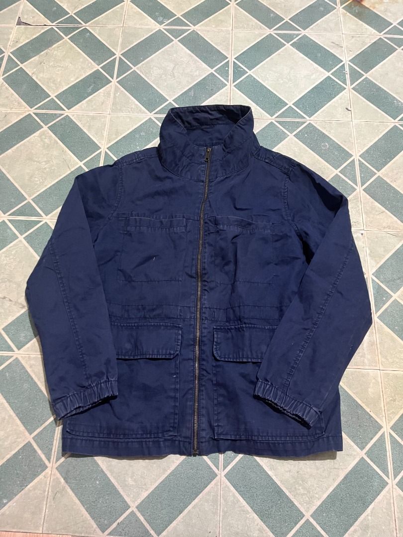 Navy Blue Utility Jacket With Multiple Pockets (Category: Coats, Jackets and Outerwear) located in Pateros City. Submitted by m4ry.b0o (Listing ID 1469821594, Image 2). Description: - Color: Dark blue - Material: Durable cotton - Closure: Full zip front with high collar - Pockets: Four front flap pockets - Fit: Snug with elastic cuffs and hem - Style: Practical utility jacket, ideal for layering on cooler days.