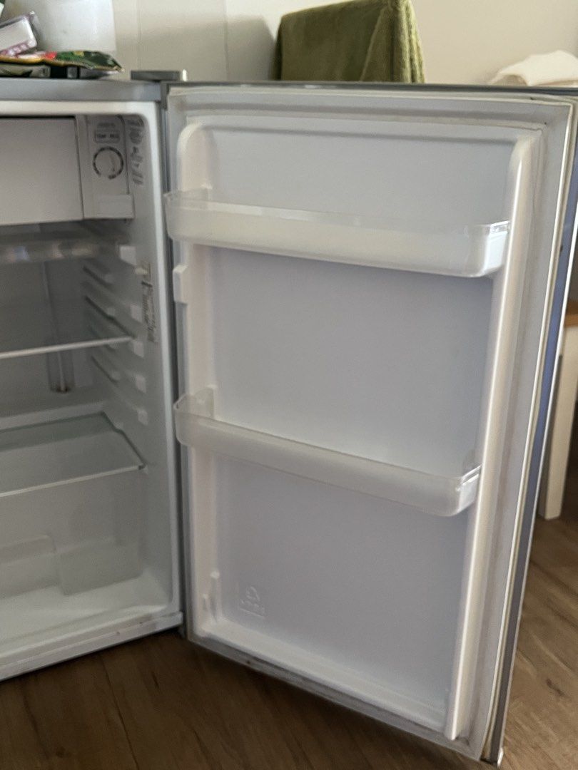 [Needs fixing] Kelvinator KPR121MN 100L Refrigerator (Category: Refrigerators and Freezers) located in Taguig. Submitted by albm.business (Listing ID 1469909809, Image 3). Description: - Brand: Kelvinator - Model: KPR121MN - Capacity: 100 Liters (single door mini fridge) - Color: Silver exterior with clean white interior - Features: Removable glass shelves, crisper drawer, and door bins - Temperature Control: Adjustable dial located inside at the