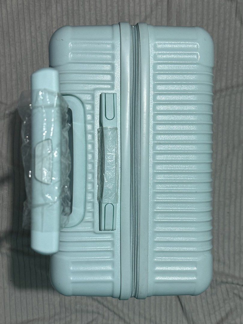 NEP Mint Green Luggage Striped (Category: Luggage) located in Quezon City. Submitted by shanebunag (Listing ID 1469824717, Image 2). Description: Light blue hardside suitcase with ribbed texture. Built-in combination lock on the side. Four smooth-rolling swivel wheels. Retractable handle and side handle wrapped in protective plastic. Fully lined interior in dark grey fabric, featuring zipper mesh compartments on one side and adjustable elastic pa