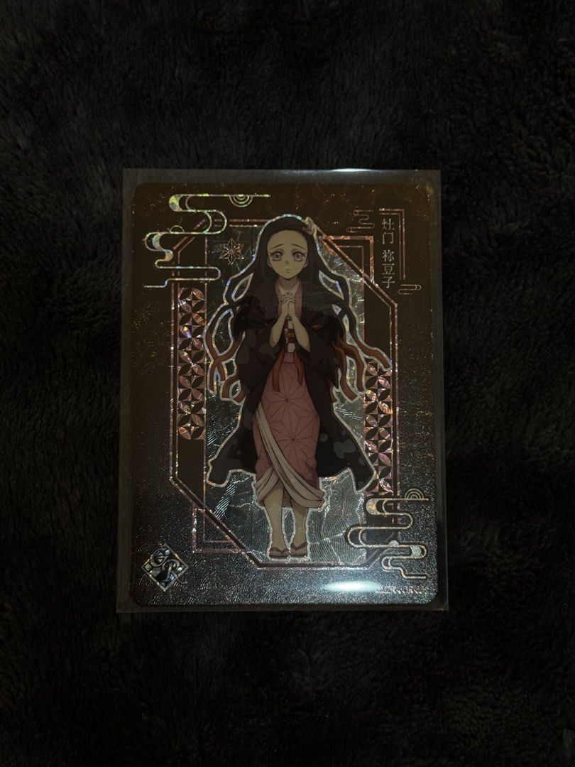 Nezuko Kamado GR (Category: Raw Singles) located in Cavite. Submitted by devareaux (Listing ID 1469866210, Image 1). Description: - Character: Nezuko Kamado (Demon Slayer / Kimetsu no Yaiba) - Brand: Kayou - Finish: Holographic with intricate borders and Japanese text - Condition: Near Mint / Pull-to-sleeve - Protection: Kept in a protective sleeve since pulling, clean surface, and sharp corners.