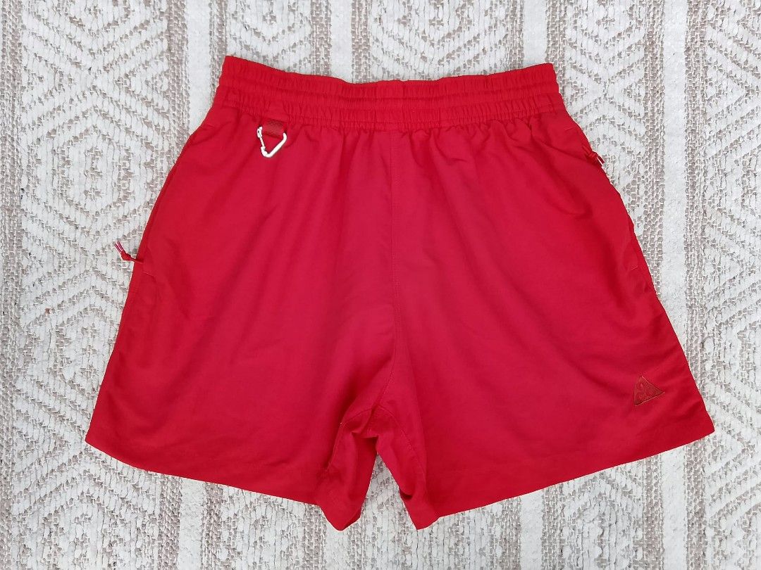 Nike ACG Red Short (Category: Shorts) located in Quezon City. Submitted by cruz_robert (Listing ID 1469808002, Image 1). Description: - Brand: Nike ACG - Color: Bright Red - Size: Small to medium - Condition: Brand new / Excellent - Elastic waistband with interior drawstring for an adjustable fit - Built-in carabiner clip on the front loop for gear attachment - Secure zipper pockets on the sides - Embroidered triangle ACG logo on the lower right 
