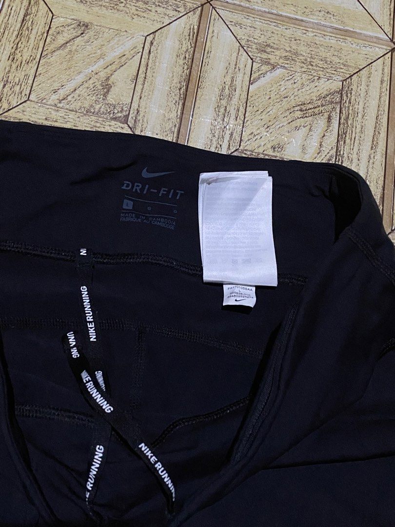 Nike Dri-FIT Running Leggings Size L (Category: Activewear) located in Manila. Submitted by tygaangub1096 (Listing ID 1469877600, Image 3). Description: Black Nike Dri-FIT running leggings in size large. Reflective swoosh logo on the front thigh. Inner drawstring waistband with repeating Nike Running print. Small zippered pocket on the back waistband. Moisture-wicking material. Great workout gear for training or daily runs. - Large on tag - Add s