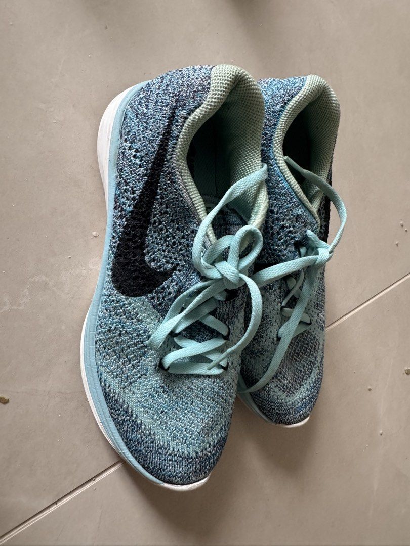Nike Flyknit Running Shoes Blue Black (Category: Sneakers) located in Quezon City. Submitted by tinylee60 (Listing ID 1469767477, Image 2). Description: - Brand/Model: Nike Flyknit Running Shoes - Colorway: Blue and black upper with light blue laces, white midsole, and black/green rubber tread - Condition: Uppers hold shape well; soles show visible dirt and wear from previous runs - Features: Lightweight knit upper, comfortable cushioning - Ideal