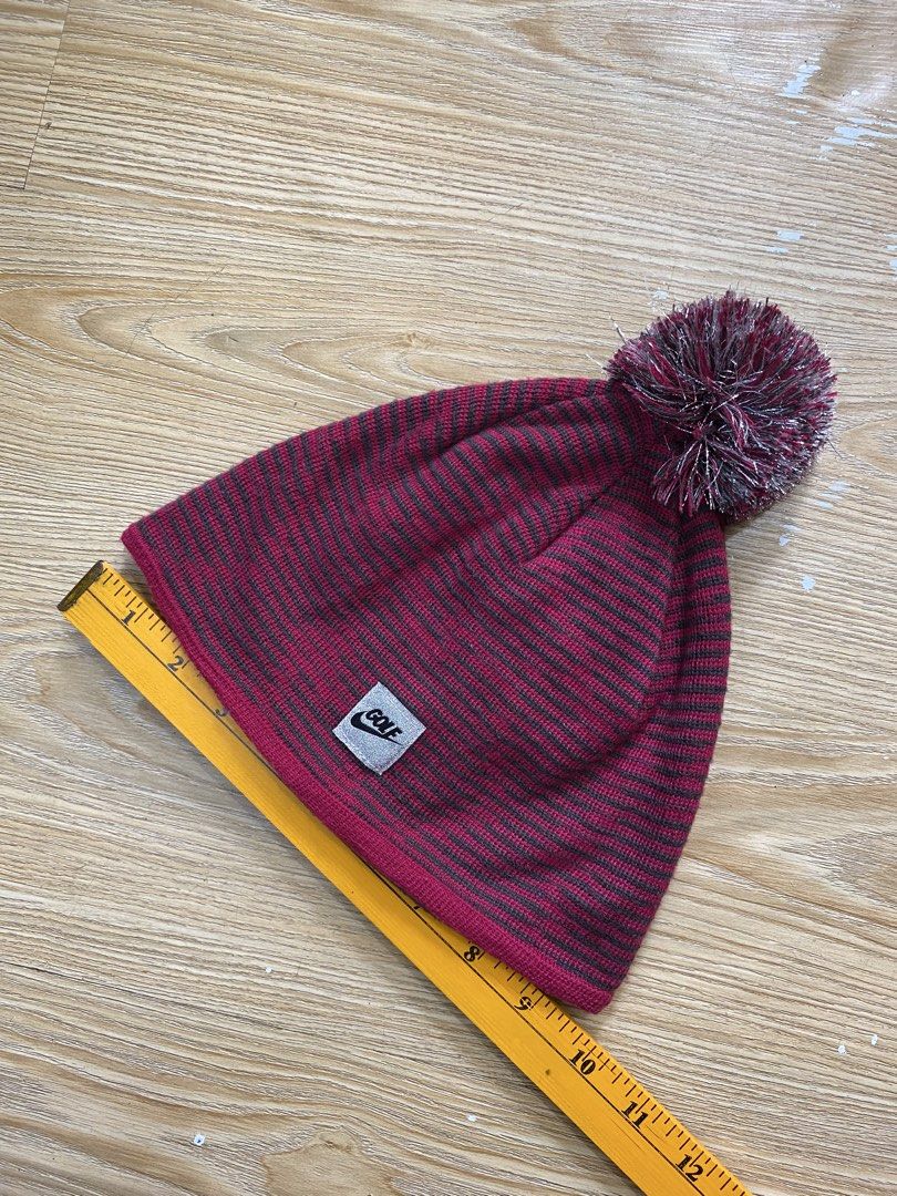 NIKE GOLF,Beanie (Category: Hats & Beanies) located in Cavite. Submitted by jc_thrift95 (Listing ID 1469873741, Image 3). Description: - a Nike Golf winter knit beanie in a reddish-pink and gray striped pattern with a matching pom-pom on top and a front brand patch. - Made in Taiwan - Color rate 8/10 - See picture details for dimes..