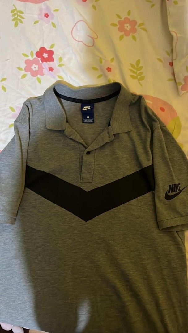 Nike Gray Polo Shirt Size L (Category: Tshirts & Polo Shirts ) located in Manila. Submitted by zaint2mfy (Listing ID 1469869416, Image 1). Description: - Brand: Nike - Style: Polo shirt with black chevron stripe across the front - Color: Gray - Size: Large (blue tag) - Features: Classic collar with buttons, short sleeves, small Nike logo on the left sleeve - Origin: Made in China - Condition: Excellent pre-loved condition - Perfect for: Casual ou