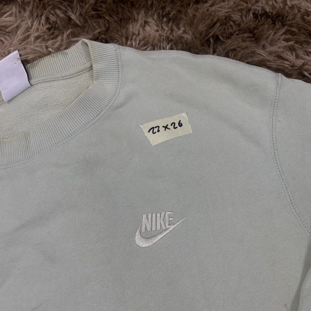 Nike Green Sweatshirt Size M (Category: Coats, Jackets and Outerwear) located in Cagayan de Oro. Submitted by sepamorash53558 (Listing ID 1469796854, Image 2). Description: - Brand: Nike - Item: Crewneck Sweatshirt - Color: Light Green - Size: Medium (Tag indicates 95cm chest) - Material: 100% cotton body with 4% spandex ribbing - Details: Embroidered white mini swoosh on the chest - Flaws: Has a few faint yellowish spots on the front body fabric