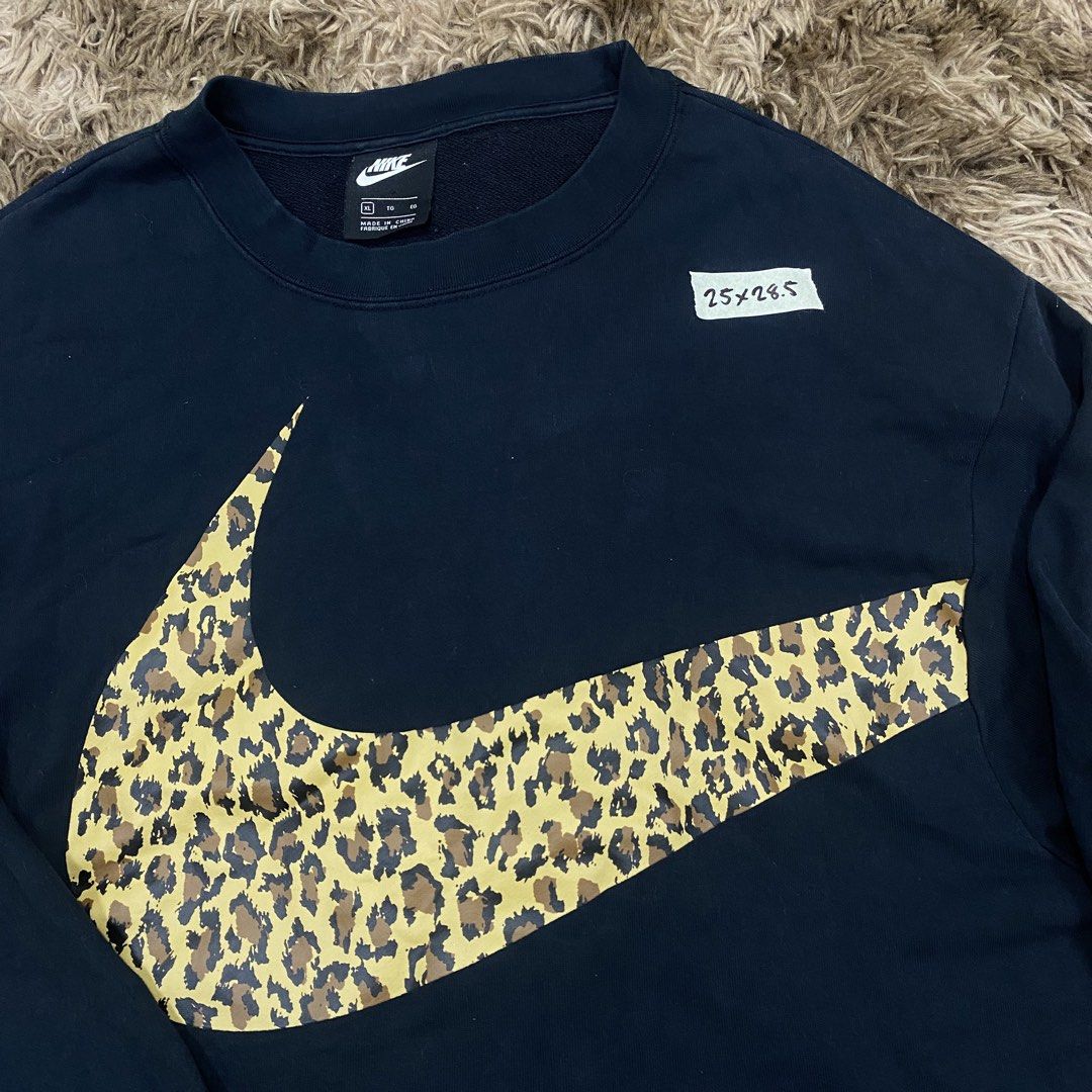 Nike Leopard Swoosh Black Sweatshirt Size XL (Category: Coats, Jackets and Outerwear) located in Cagayan de Oro. Submitted by sepamorash53558 (Listing ID 1469797440, Image 2). Description: - Brand: Nike - Color: Black - Size: XL - Material: 80% Cotton, 20% Polyester - Design: Large leopard print Swoosh graphic on the front with a matching small Swoosh wrap-around on the upper back - Style: Classic crewneck, long sleeves - Condition: Clean fabric 