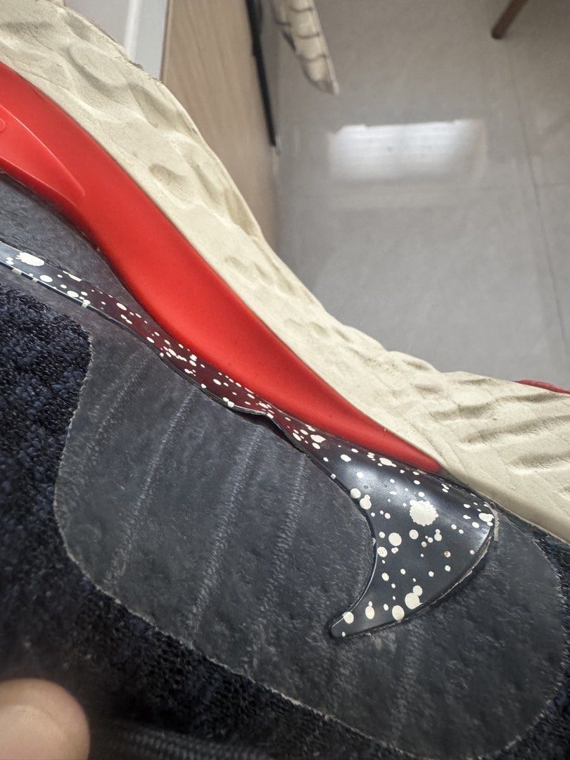 Nike React Running Shoes Black Red (Category: Sneakers) located in San Fernando. Submitted by jelajoybasco (Listing ID 1469781866, Image 2). Description: Nike React running shoes in black and red. White textured soles with some dirt wear from past runs. Speckled paint design on the side swoosh. Bright red inner lining and midsole strip. Laces included, shoes tie up securely. Good option for gym sessions or daily jogging. Issue: The Nike logo/over